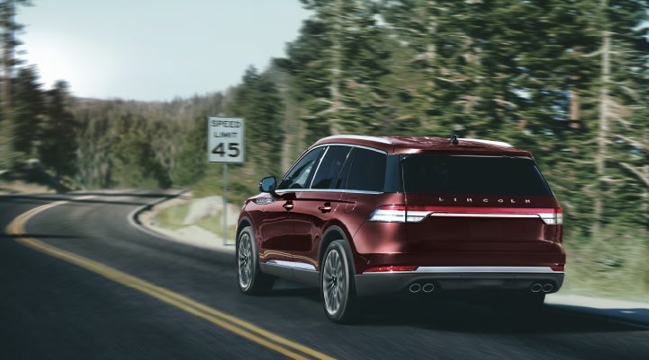 A 2024 Lincoln Aviator® SUV is being driven on a winding mountain road | Brinson Lincoln of Corsicana in Corsicana TX